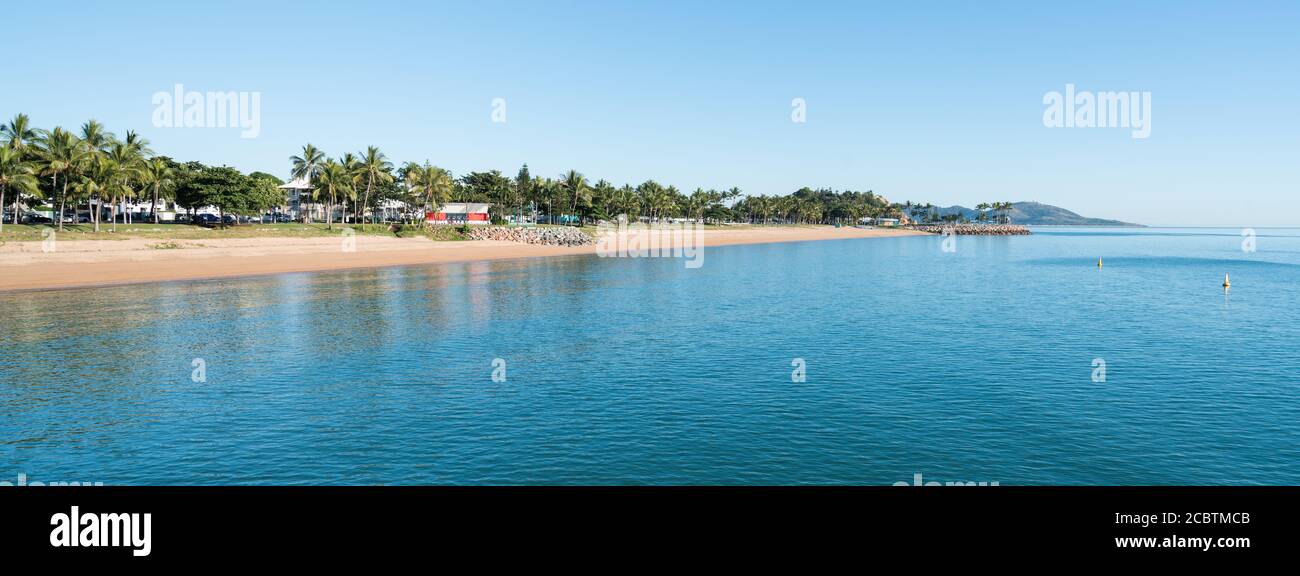 Clear blue sky and palm tree lined The Strand beach, Townsville with blue sea Stock Photo