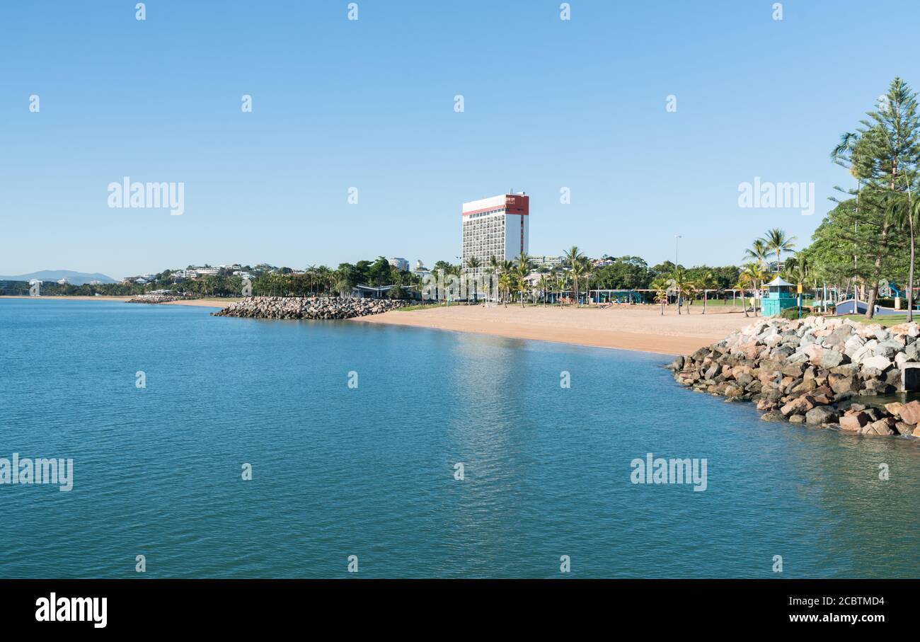 The tropical beach and Strand park with one of the few high rises built on The Strand, Townsville, North Queensland, Australia Stock Photo