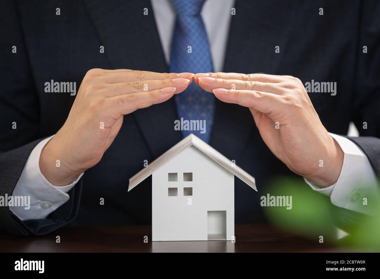 Businessman with house model on the desk. Real estate concept. Stock Photo