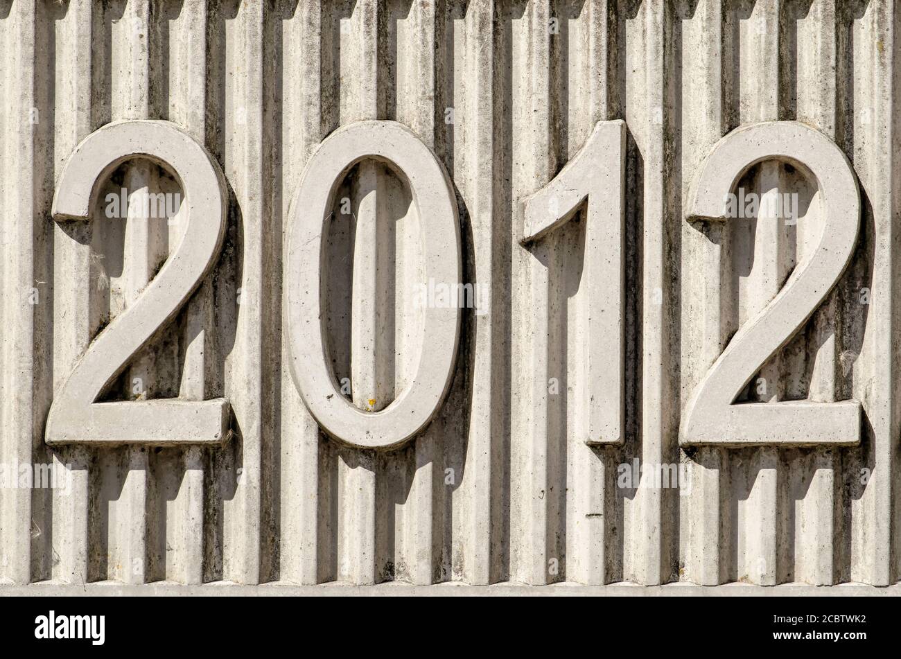 Concrete date-stone with a relief of vertical lines and the year 2012 Stock Photo