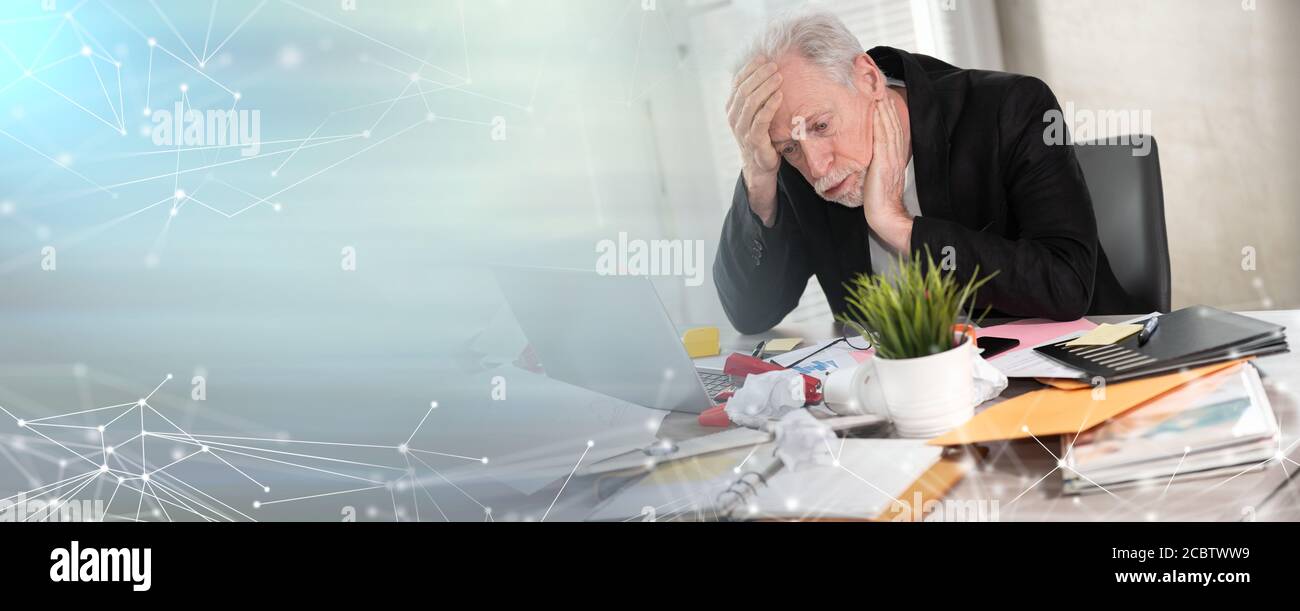 Overworked senior businessman sitting at a messy desk; panoramic banner ...