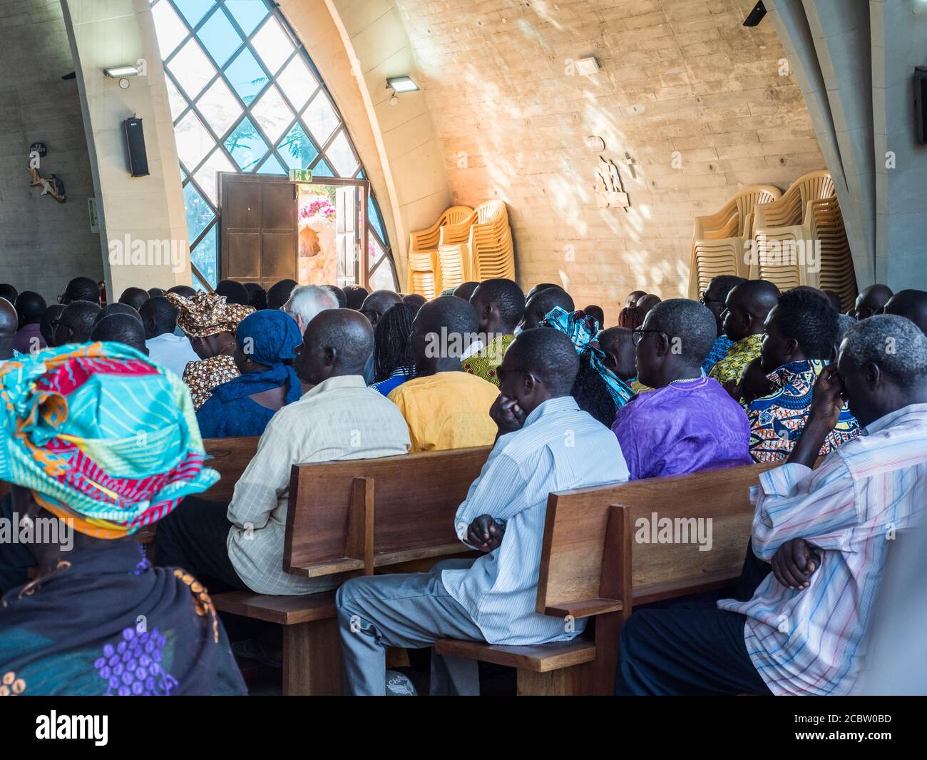 Senegal, Africa - January 2019: African people in colorful clothes (boubou) during a mass at a Catholic church in West Africa Stock Photo