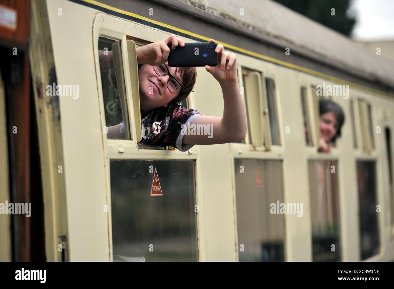 Cameras at the ready, Corey Hackling (14) gets his shot.   Gloucestershire Warwickshire Steam Railway ran its first train today since lockdown started Stock Photo