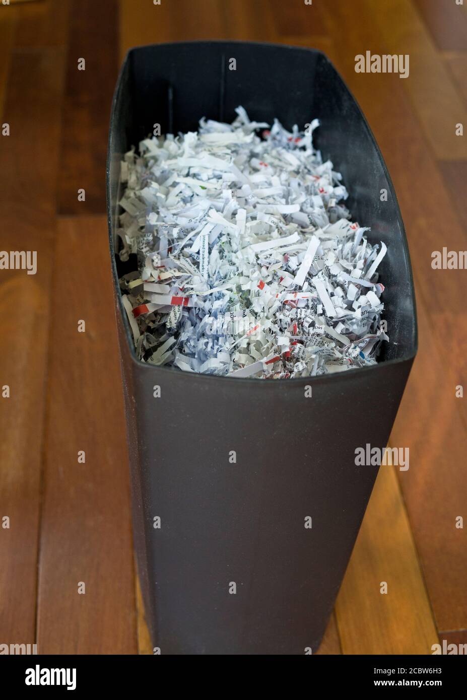 A full paper shredder.  Shredded paper in a cross-cut paper shredder. Stock Photo