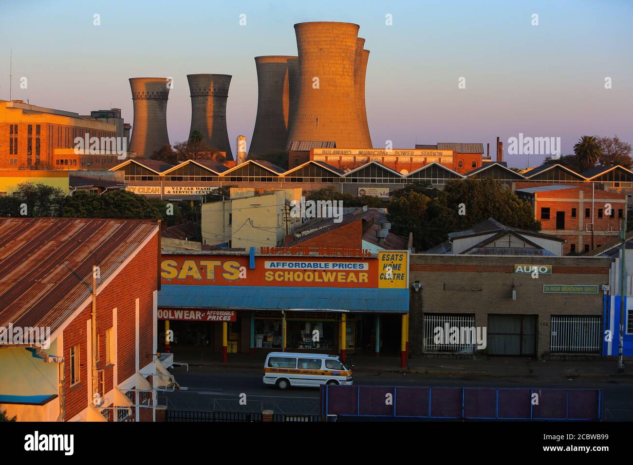 The sun rises illuminating the Bulawayo Power Station and the adjacent neighborhood. Stock Photo