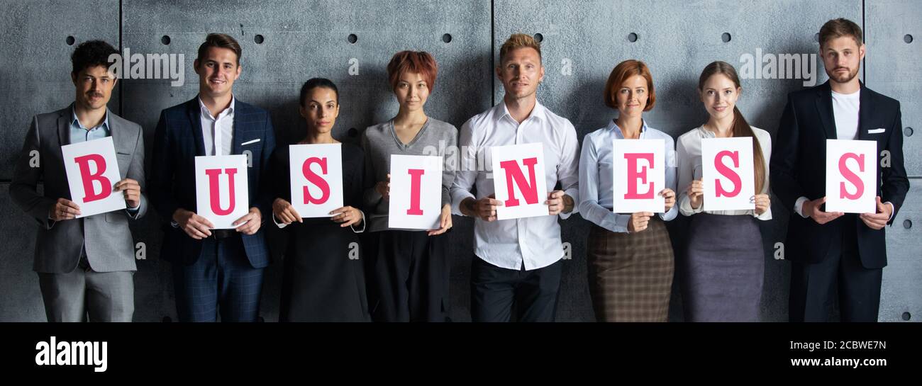 People holding BUSINESS letters printed on paper Stock Photo - Alamy