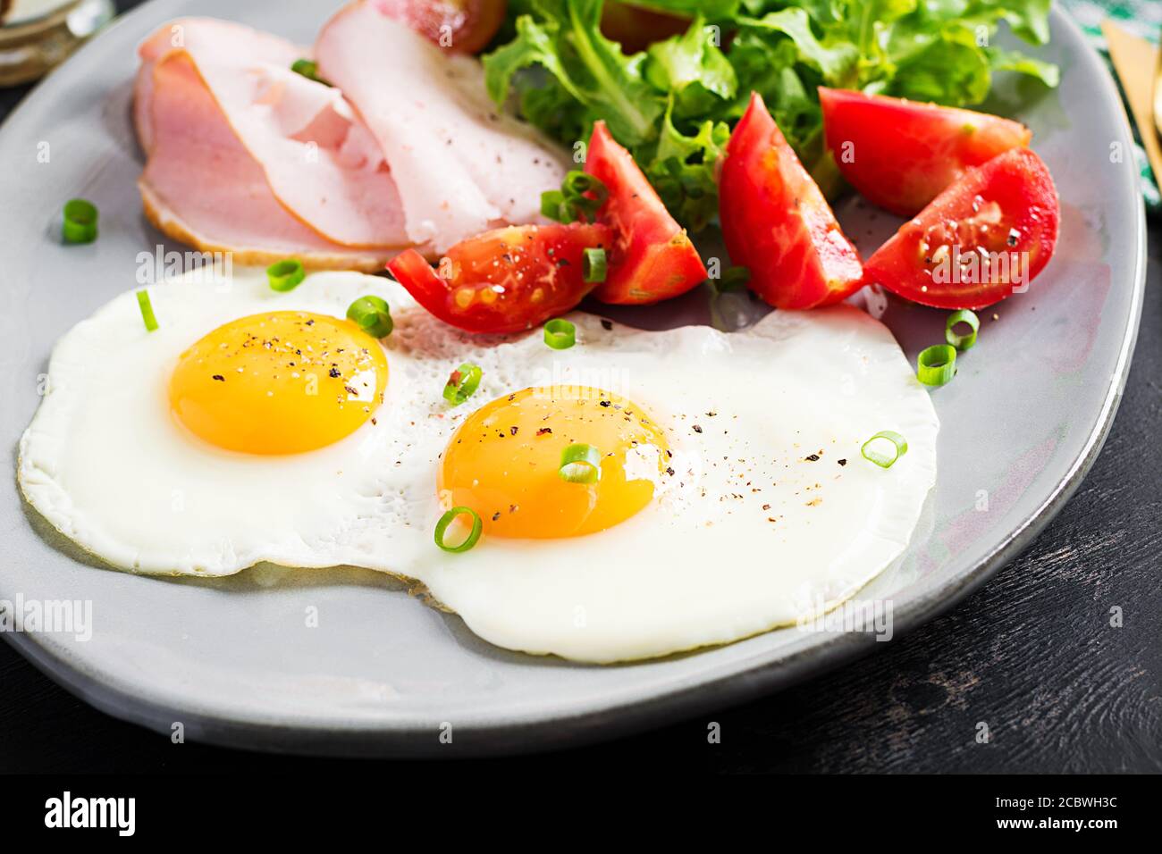 Ketogenic/paleo diet. Fried eggs, ham and fresh salad.  Keto breakfast. Brunch. Stock Photo