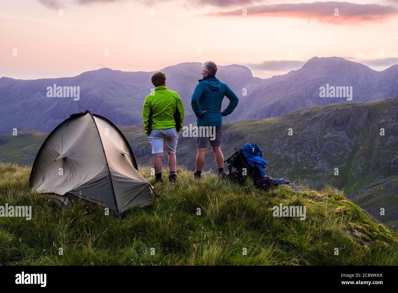 Two walkers Wild camping on Crinkle Crags whilst backpacking in the mountains of the Lake District National Park, UK Stock Photo