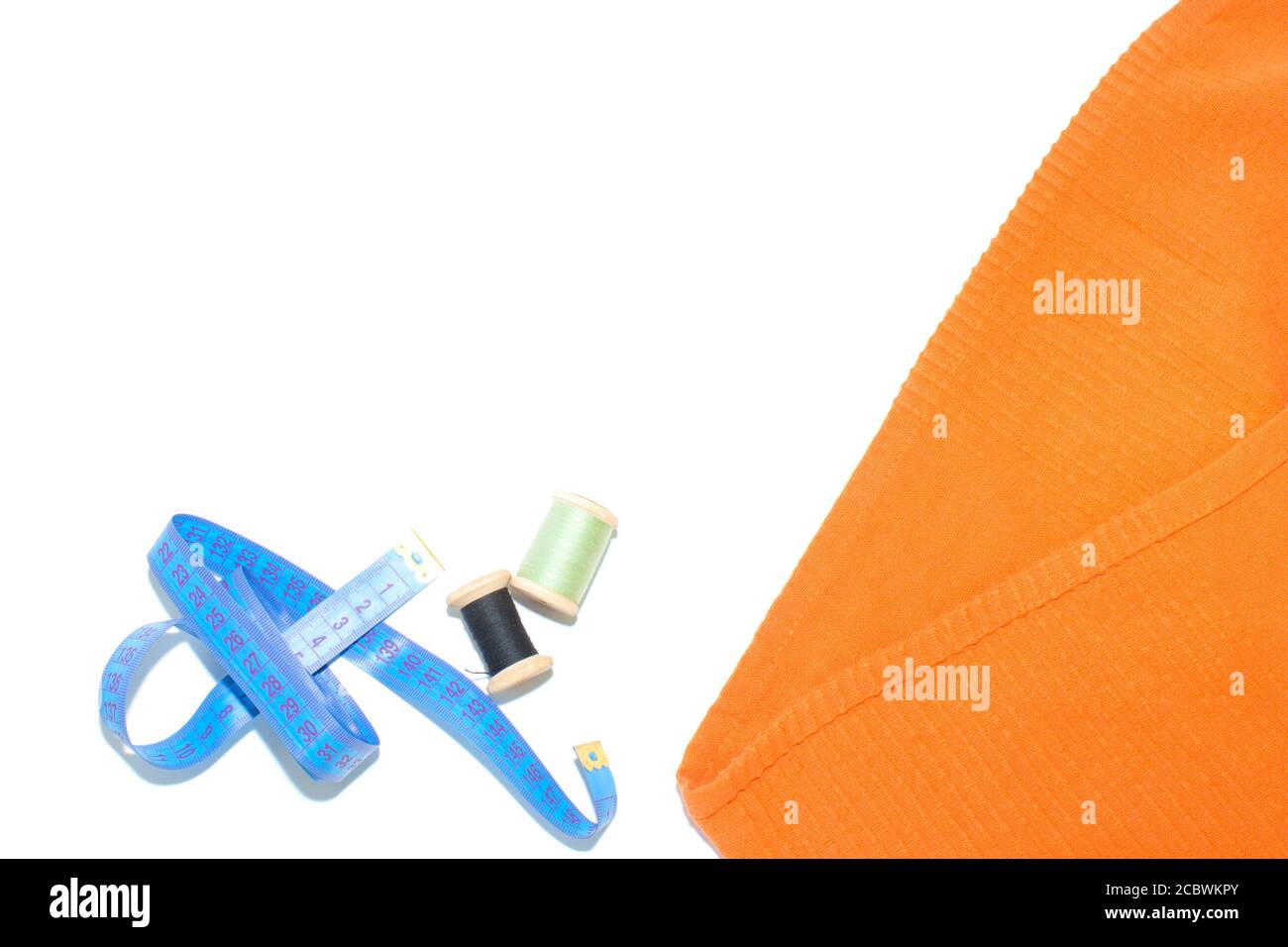 Coil with thread, scissors and ruler on a piece with a bright cloth, on ...