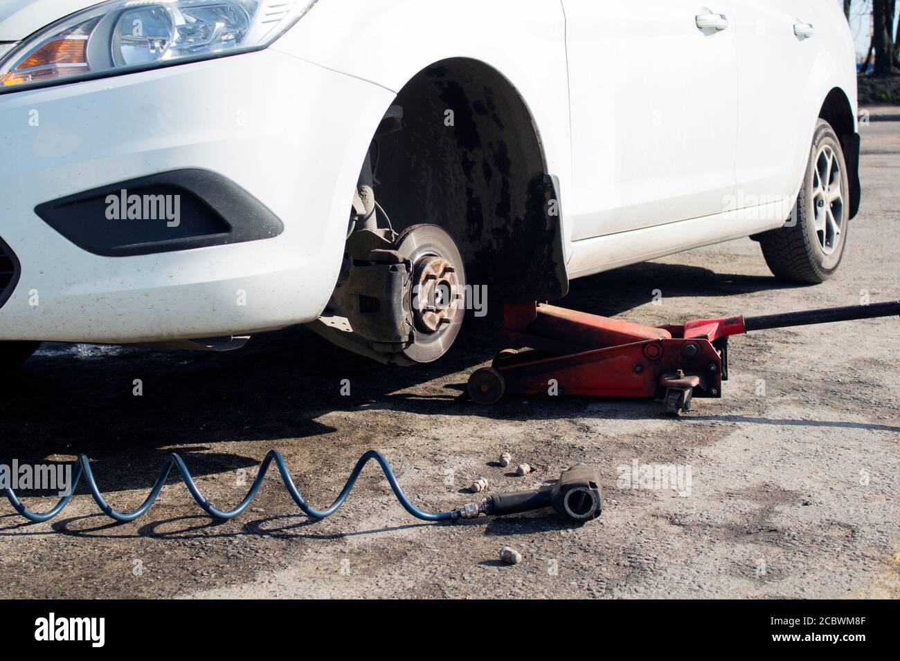 Car without wheel and lift up by hydraulic, waiting for tire replacement Stock Photo Alamy