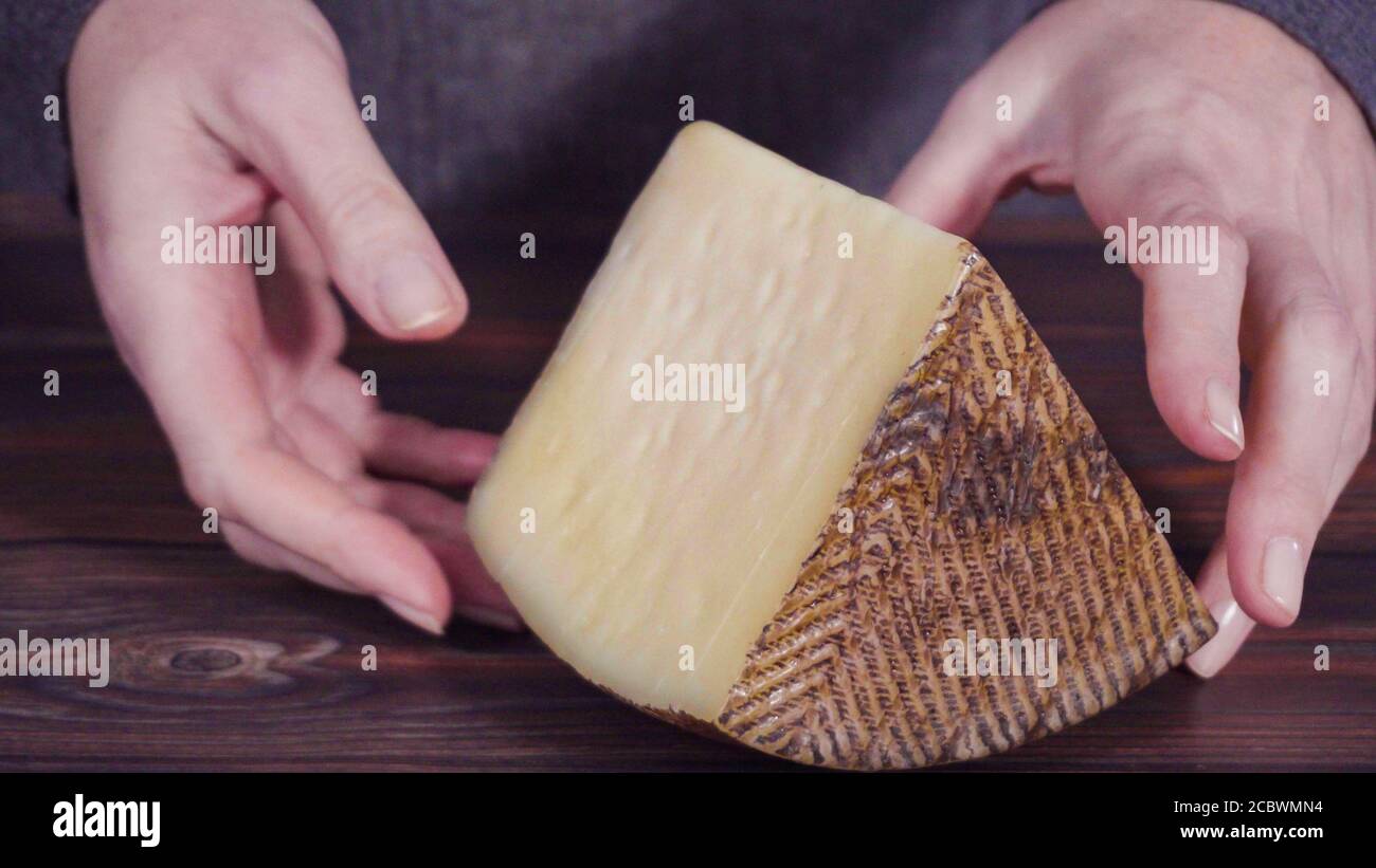 Large Wedge Of Manchego Cheese On A Rustic Wood Background Stock Photo large-wedge-of-manchego-cheese-on-a-rustic-wood-background-stock-photo