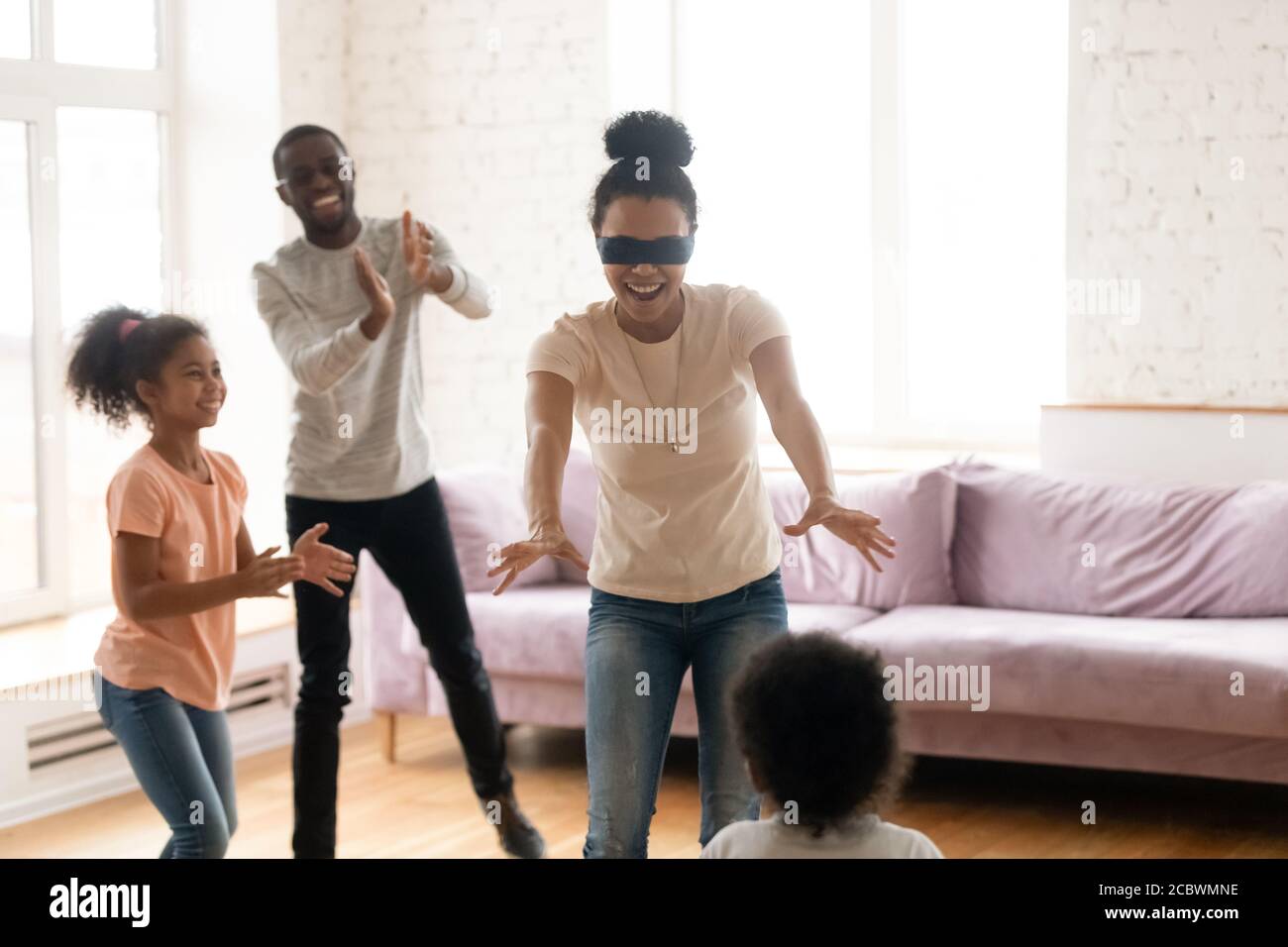 African parents and kids playing hide and clap at home Stock Photo
