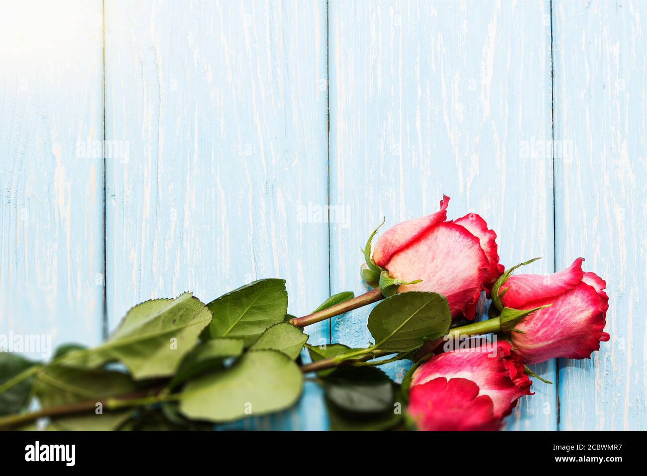 Romantic background with red roses on wood table Stock Photo - Alamy