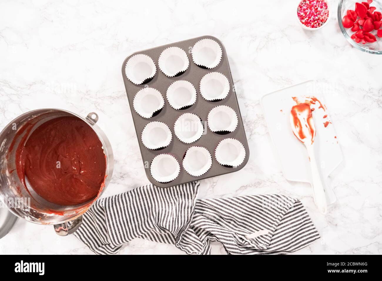 Flat lay. Flat lay. Lining cupcake pan with cupcake liners to bake red
