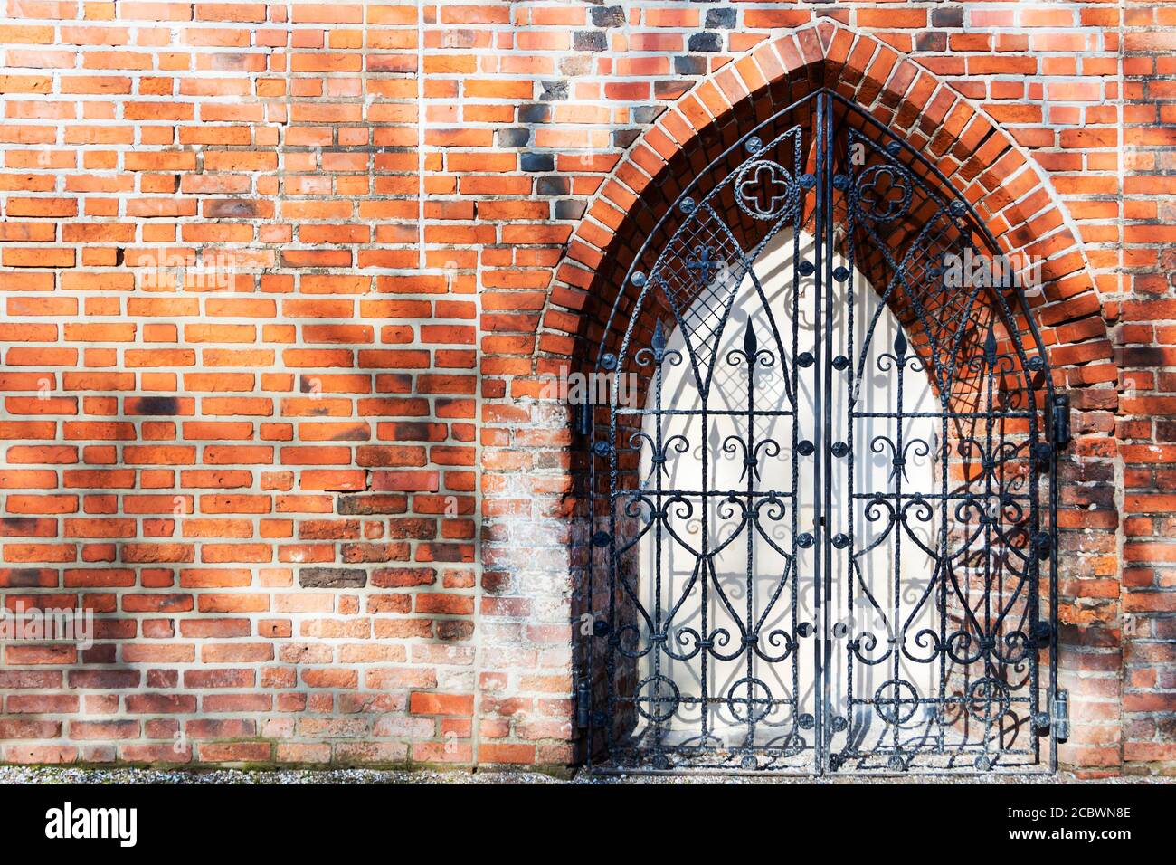 An old iron door in an old brick wall, fortification. Stock Photo