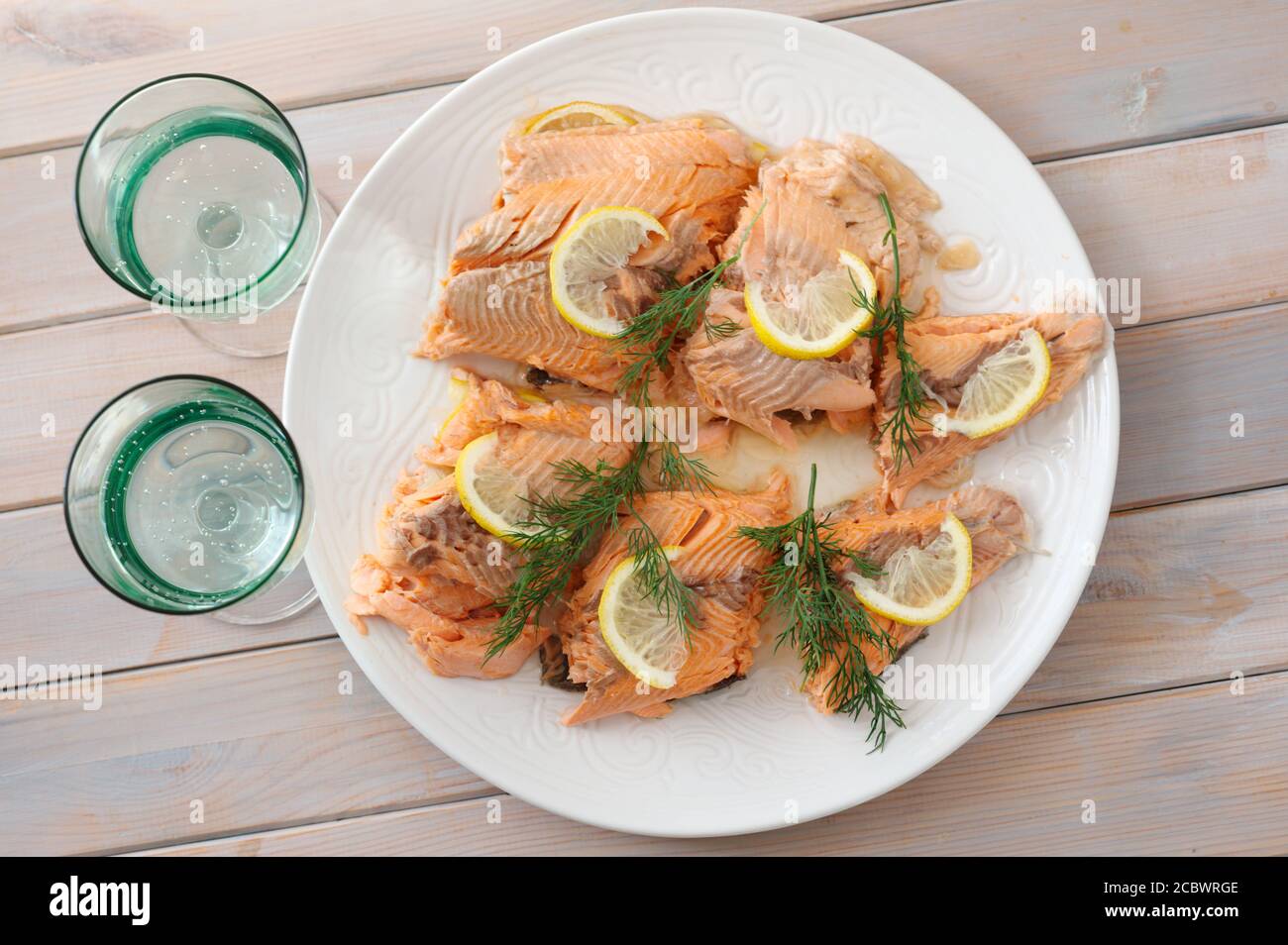 Baked trout fish served with slices of lemon and dill. Top view Stock Photo