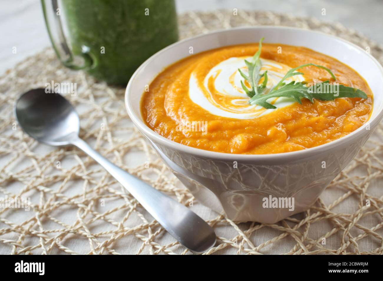 Pumpkin puree with sour cream and arugula and green smoothie Stock Photo