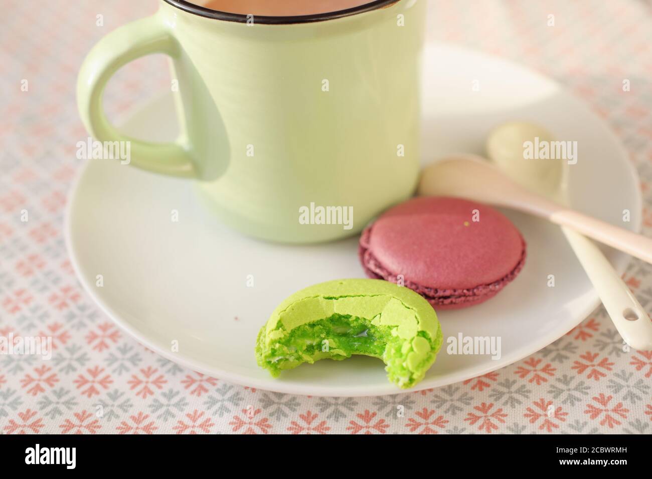Enamel mug with hot chocolate and macarons Stock Photo