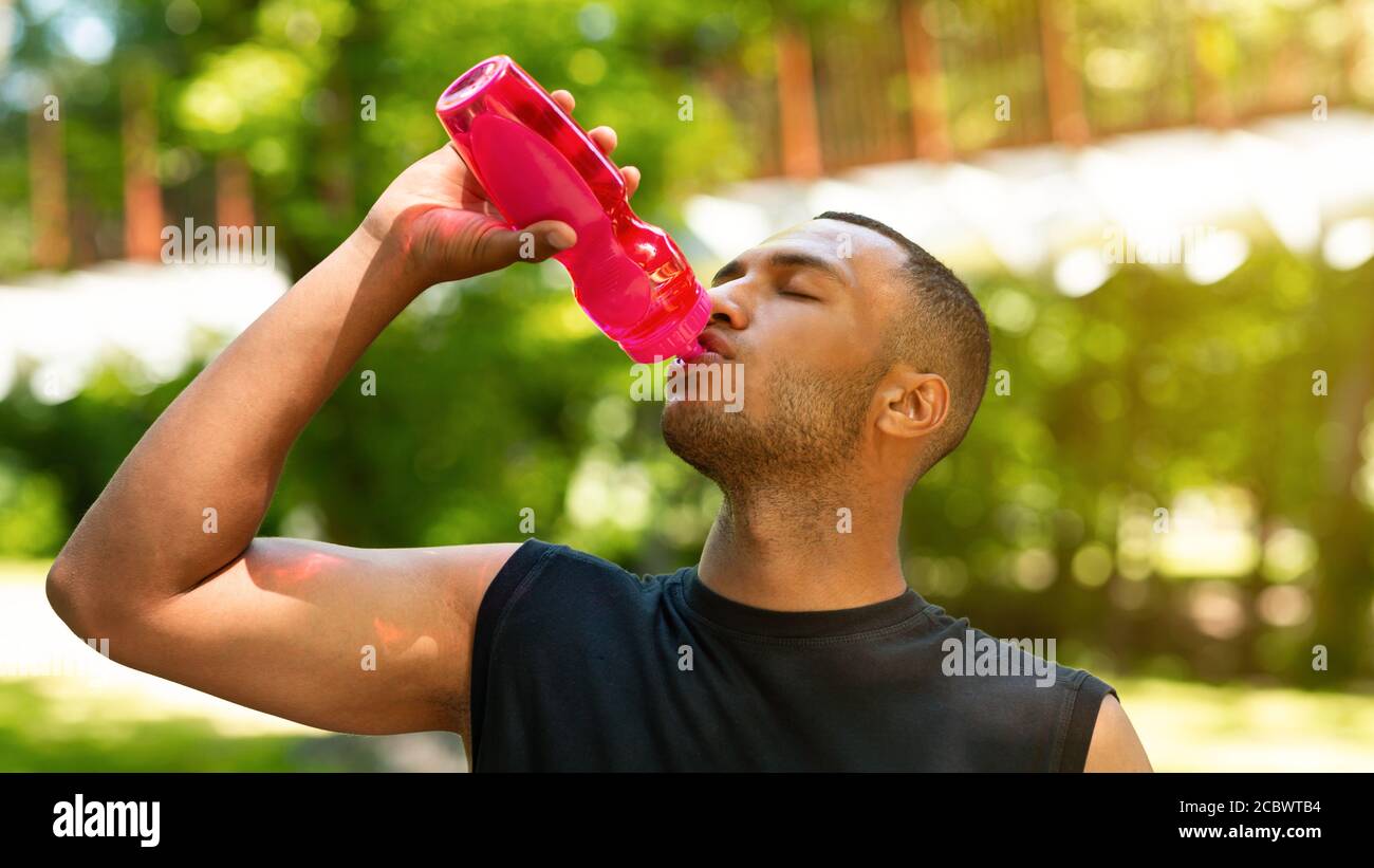 Water bottle, tired black man in gym and resting after fitness