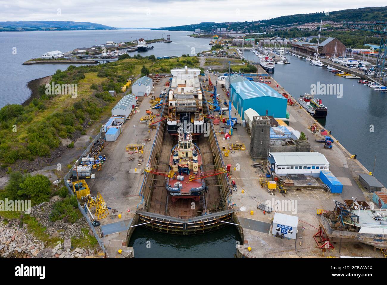 Greenock, Scotland, UK. 16 August, 2020. Aerial view of controversial CalMac ferry MV Glen Sannox in Dales Dry Dock in Greenock on the River Clyde.The partially built ferry  which is well over budget and years late, was moved from Ferguson Marine shipyard in Port Glasgow to the nearby dry dock this week for modifications to the bow, repairs and cleaning.  Iain Masterton/Alamy Live News Stock Photo