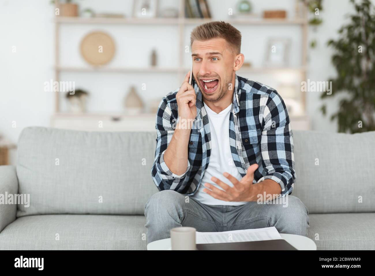 Angry man talking on mobile phone and shouting Stock Photo