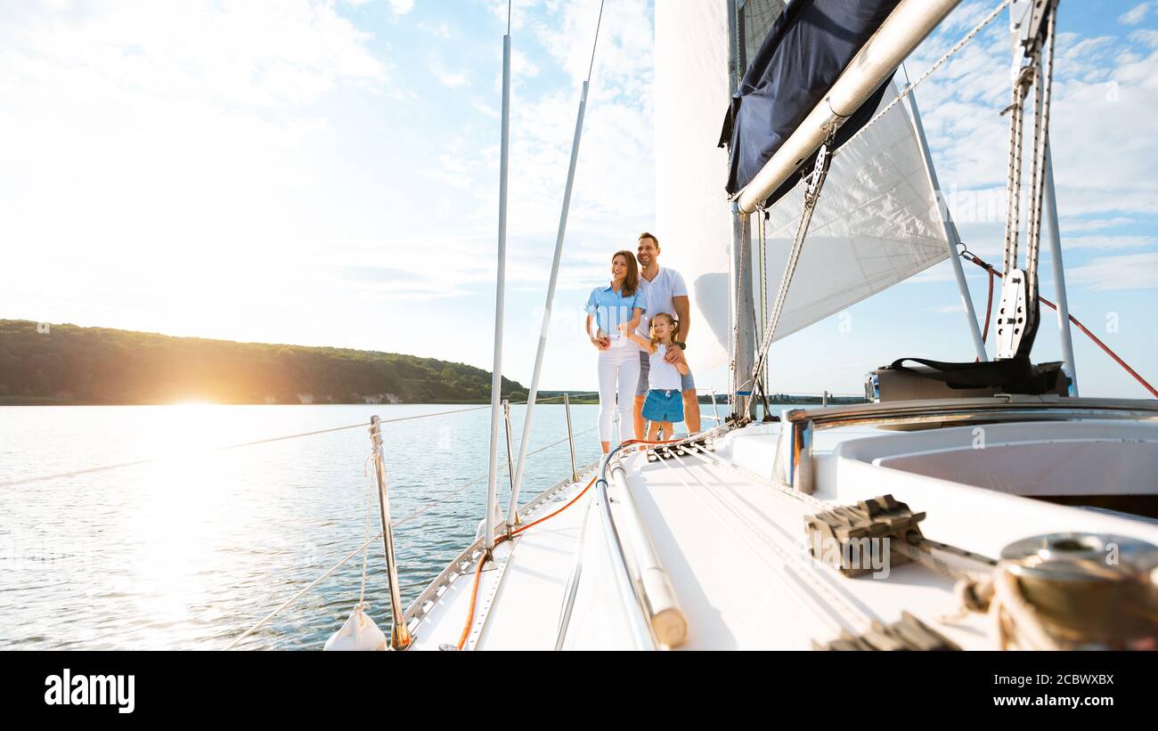 Family Relaxing On Yacht Enjoying Boat Ride Standing Outdoor, Panorama
