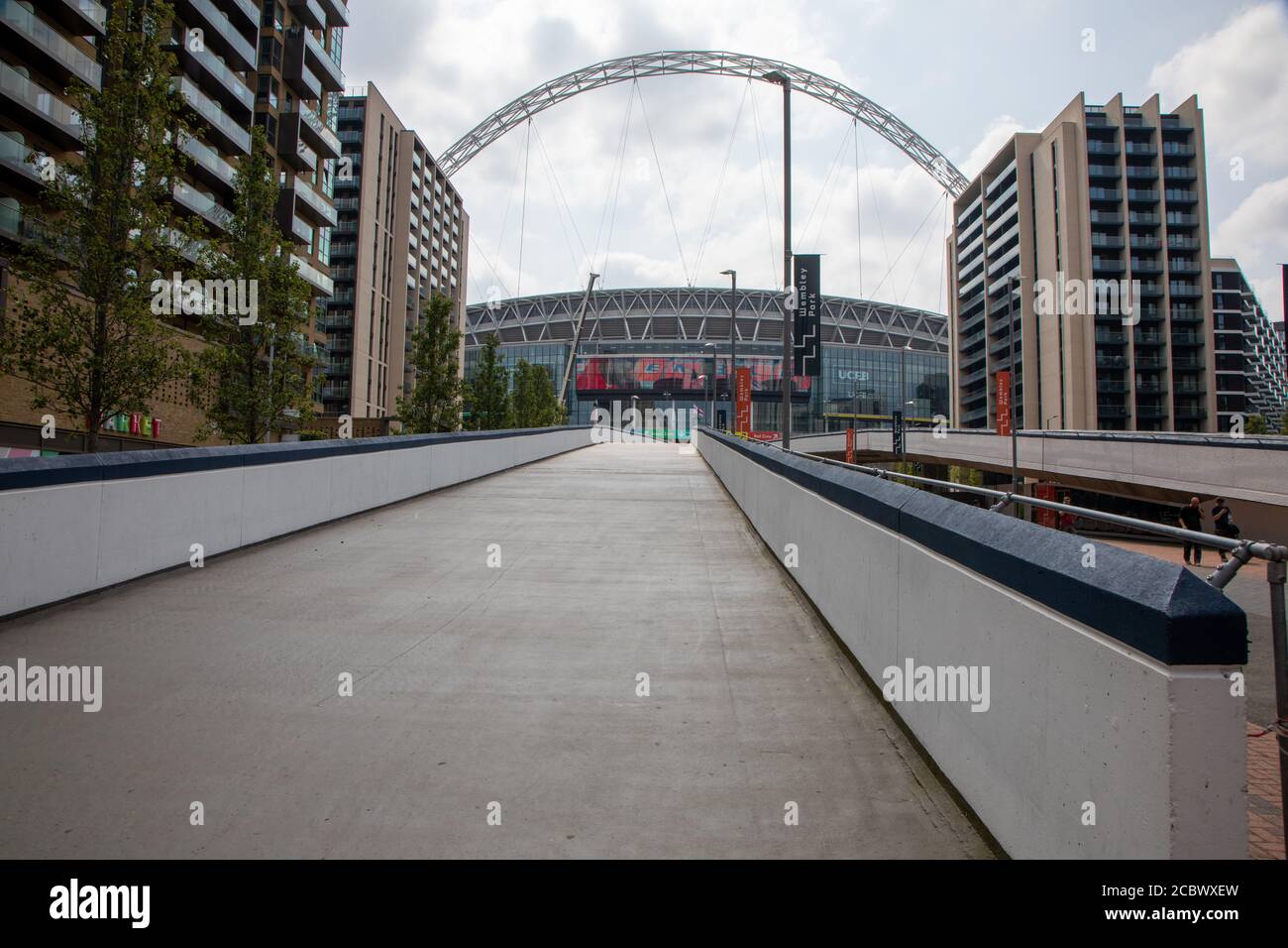 Wembley Stadium, with the pedestrian ramp in the foreground, and flanked on either side by modern housing schemes. Stock Photo