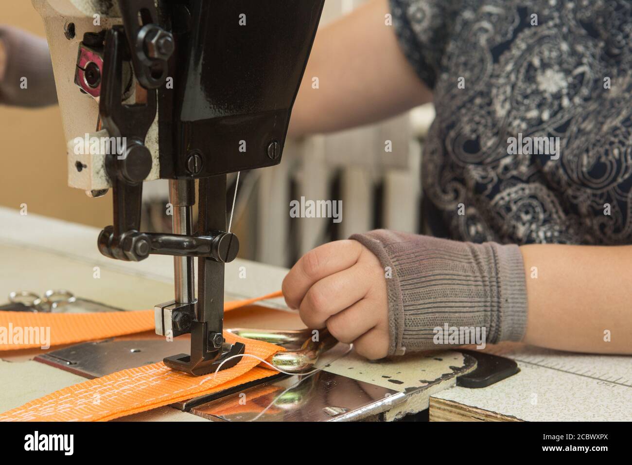 Industrial sewing machine sews a webbing sling. Manufacture of textile