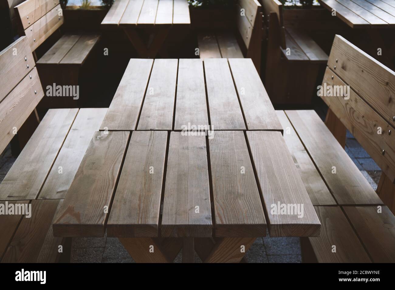 empty wooden tables and benches at deserted beergarden outdoor restaurant- off season or economy crisis concept Stock Photo