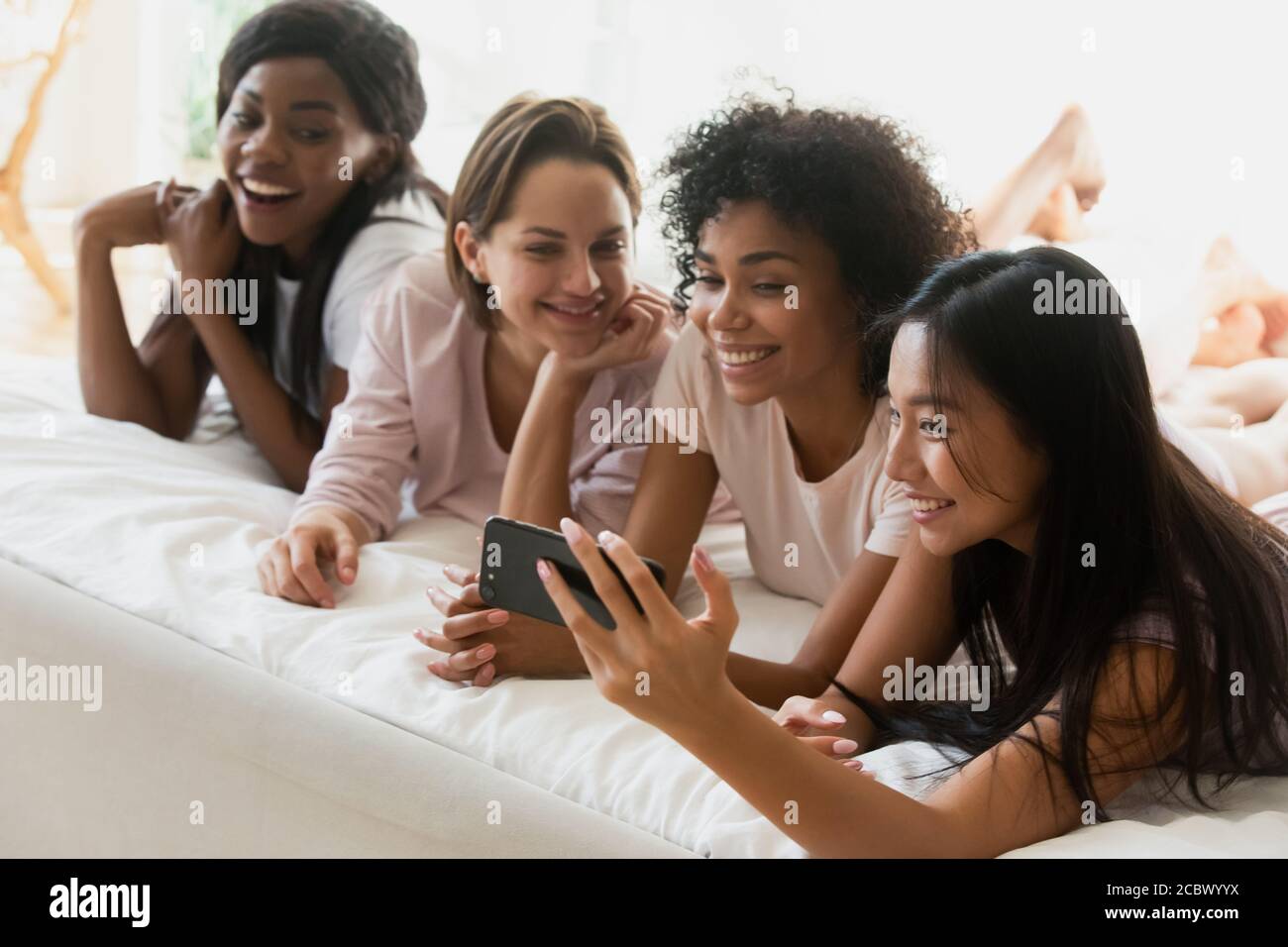 Asian ethnicity girl holding smartphone showing to intimates new app Stock Photo