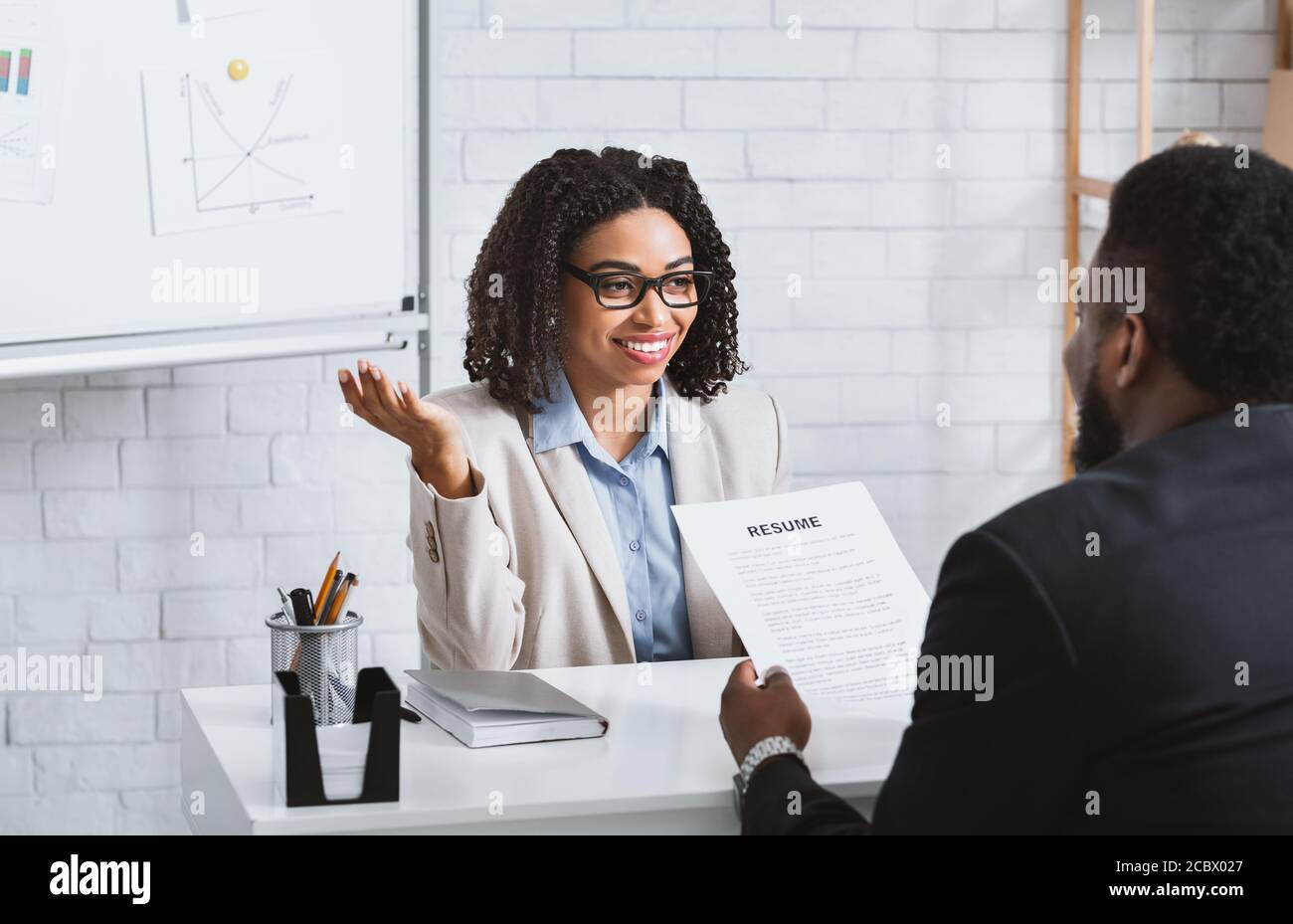 Friendly personnel manager interviewing black candidate during job interview at modern office Stock Photo