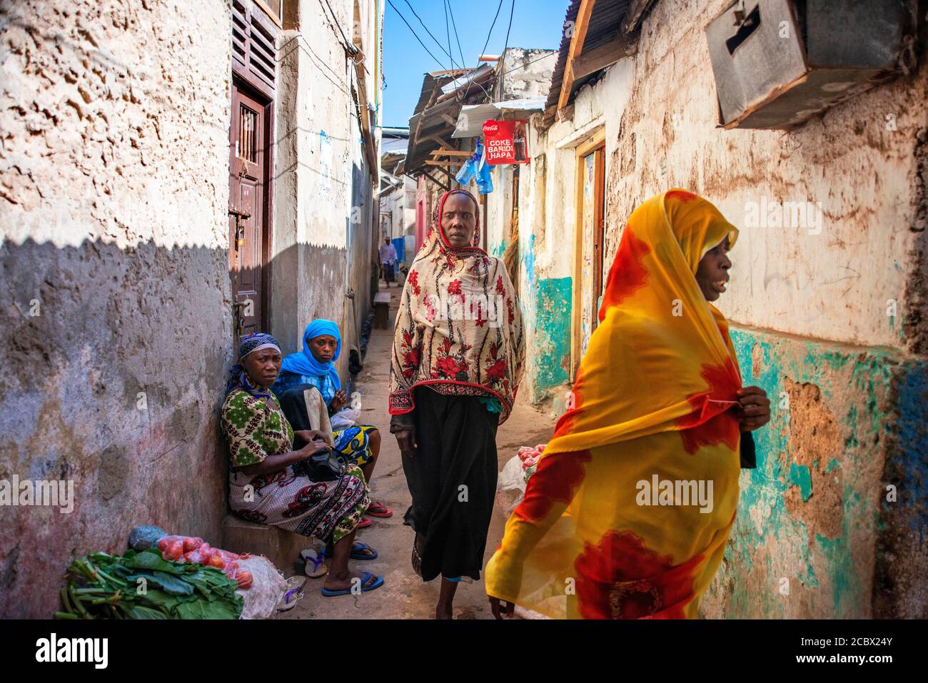 Swahili women with colorful veils in the strees of the city town of Lamu in Kenya Stock Photo