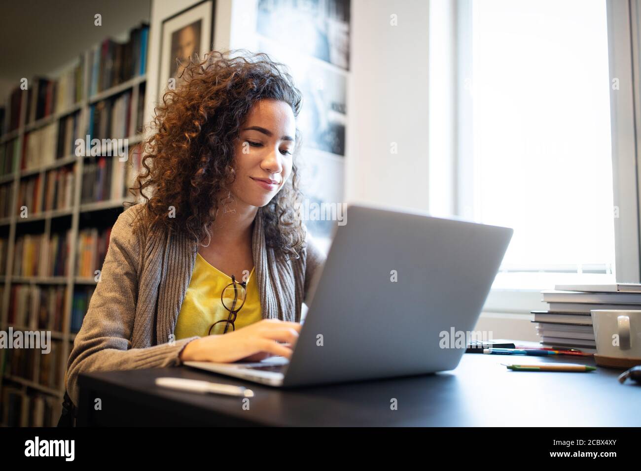 Portrait of happy student woman working on laptop Stock Photo