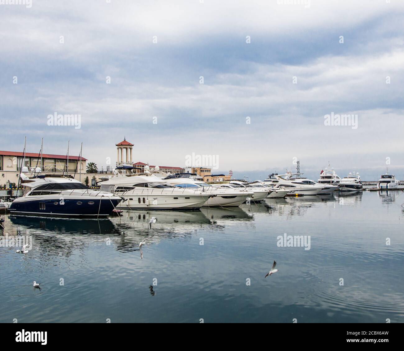 Seaport in Sochi on a cloudy day. View of the yachts from the shore. Stock Photo