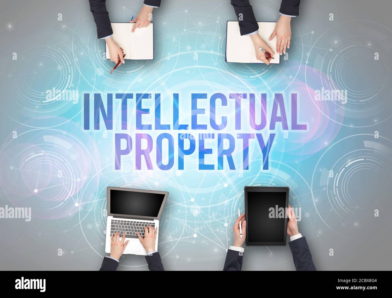 Group of people in front of a laptop with INTELLECTUAL PROPERTY insciption, web security concept Stock Photo