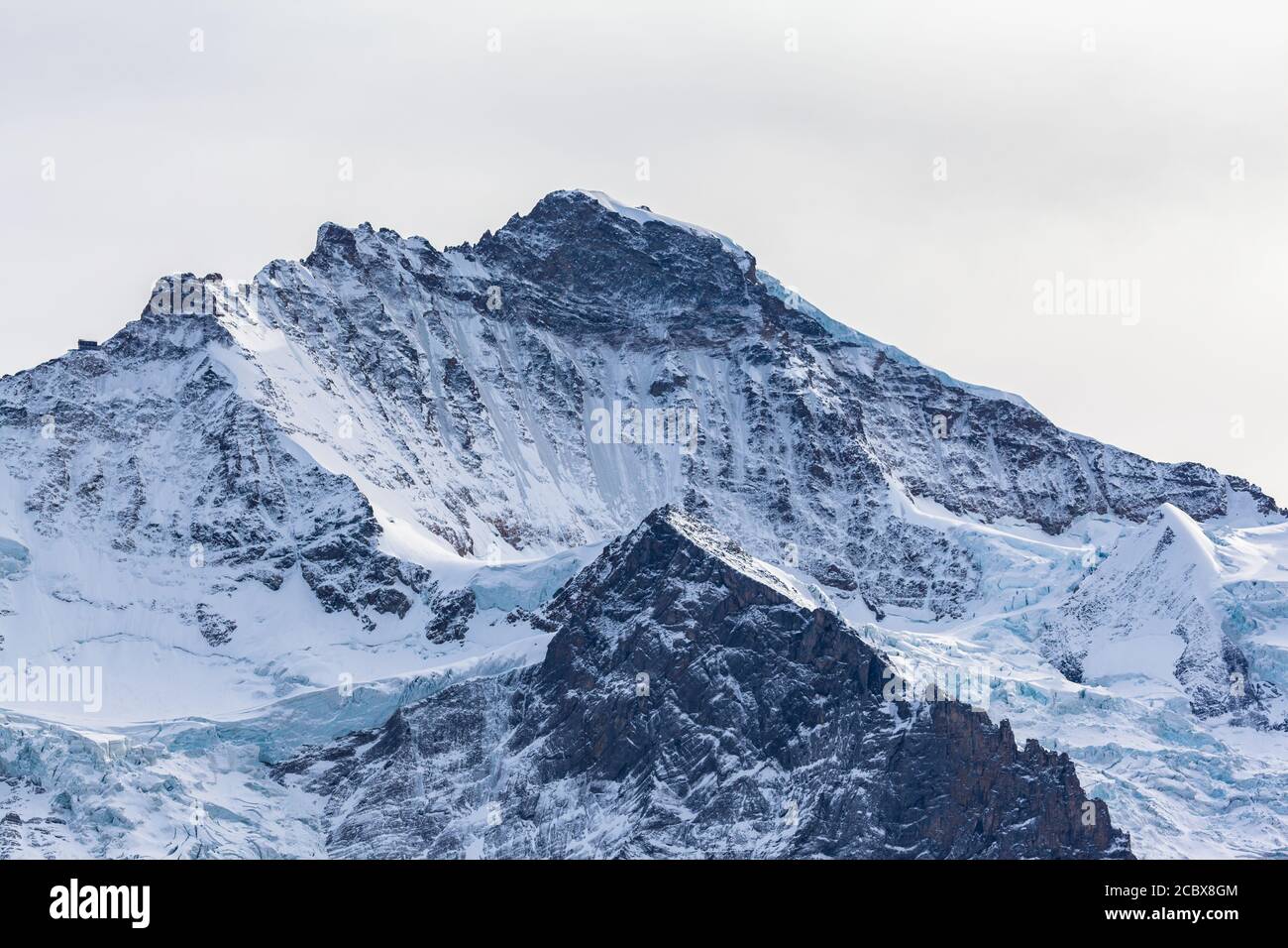 Stunning close up view of famous Jungfrau peak of Swiss Alps on Bernese Oberland  north face with glacier and snow on cloudy autumn day, Canton of Ber Stock Photo