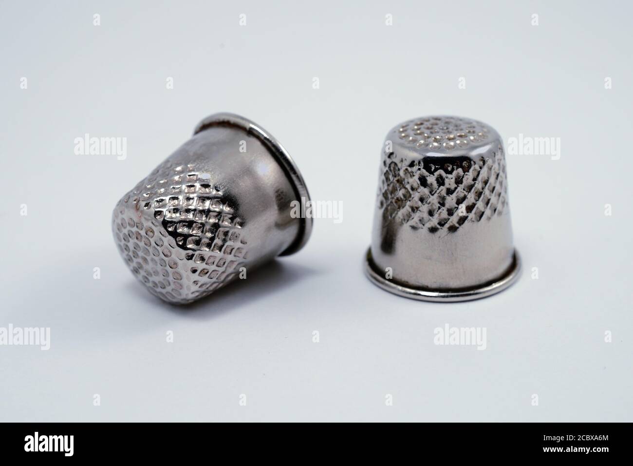 two old metal tailor thimbles on a white background Stock Photo