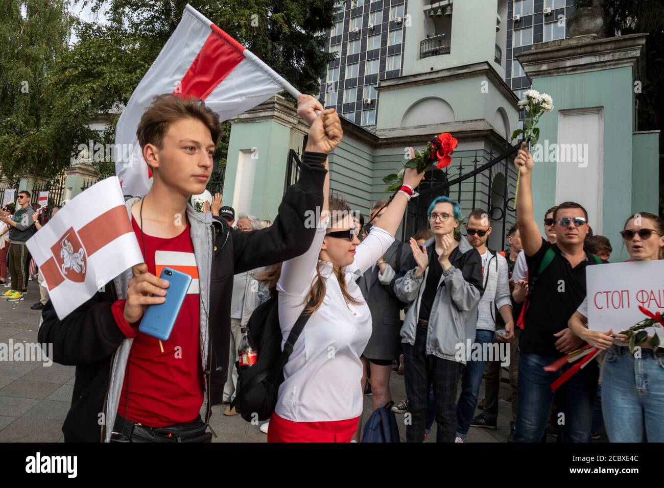 Moscow, Russia. 16th of August, 2020 Demonstrators hold a former white-red-white flag of Belarus used in opposition to the government during a protest against the results of Belarusian presidential election outside the Belarusian embassy in Moscow, Russia Stock Photo