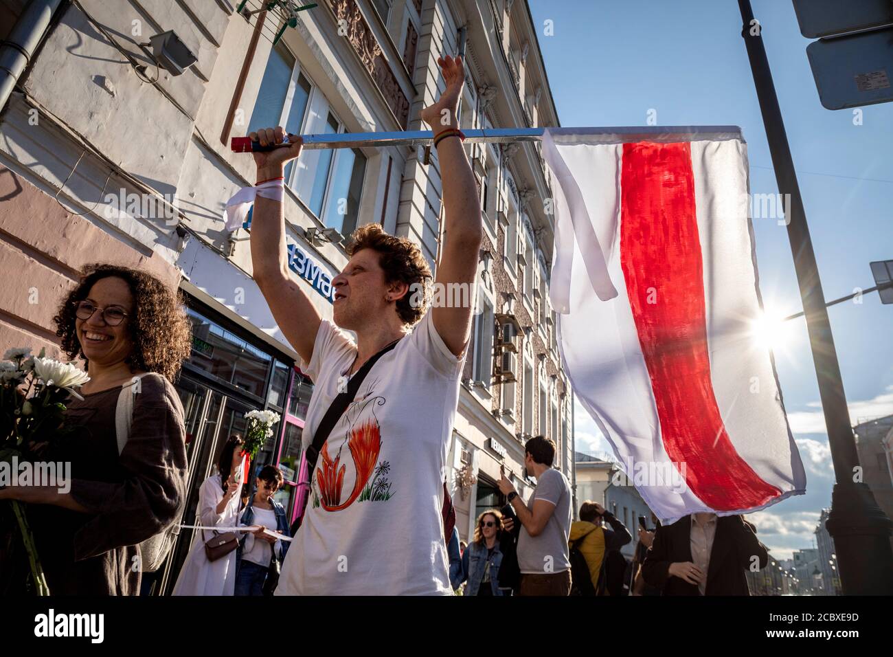 Moscow, Russia. 15th of August, 2020 Demonstrator holds a former white-red-white flag of Belarus used in opposition to the government during a protest against the official results of Belarusian presidential election outside the Belarusian embassy in Moscow, Russia Stock Photo