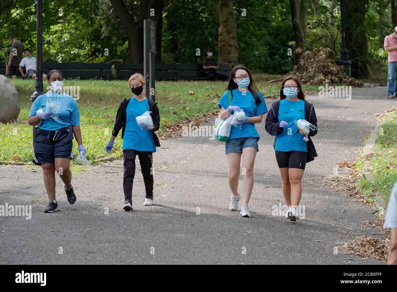 4 NYC Department of Park employees in Kissena Park handing out free surgical masks. In Flushing, Queens, New York Stock Photo