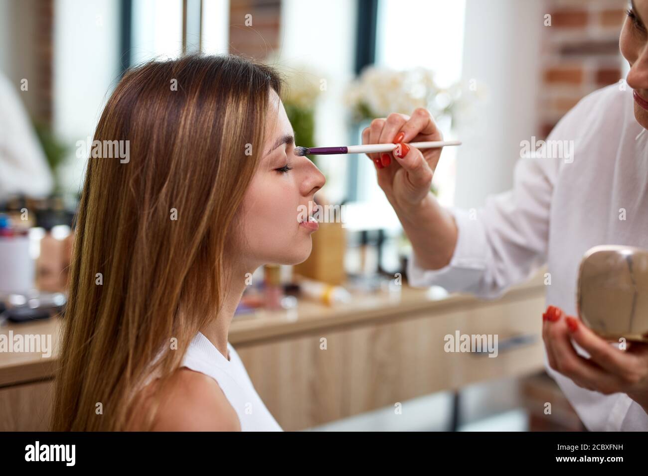 Customized Makeup Making Process process of making makeup in beauty salon. visagiste working with brush ...