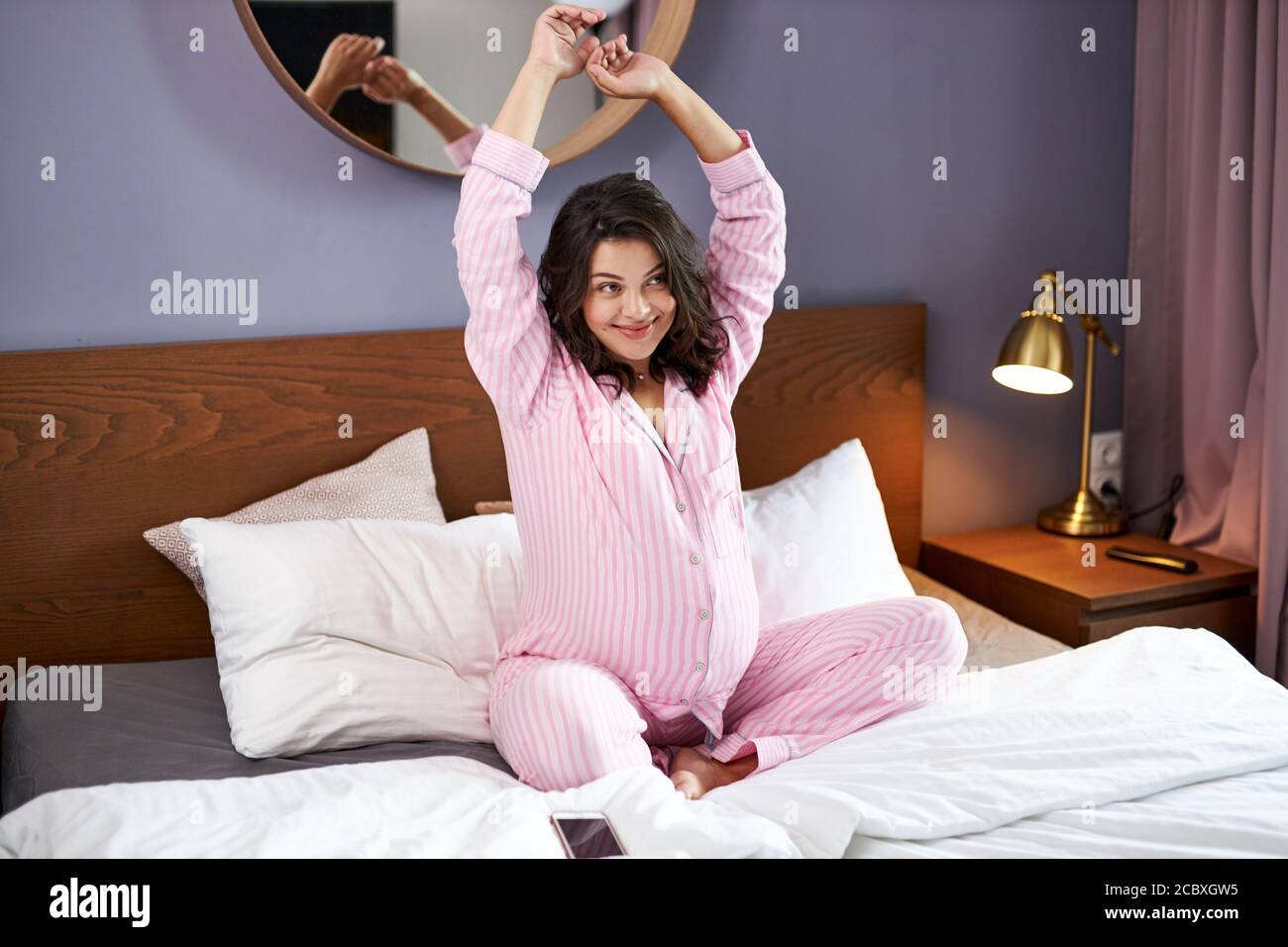 sweet smiling pregnant woman stretch in morning, wake up, have a good