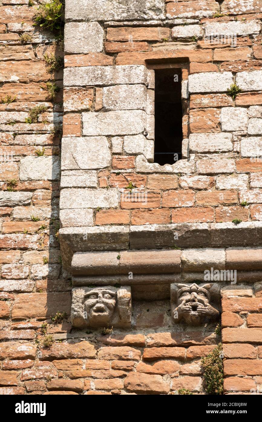 Grotesque stone carvings of faces on corbels on the ruined Brougham Castle, Penrith, Cumbria, England, UK Stock Photo