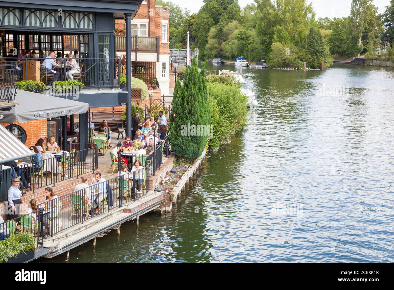 Dinners at the Cote brasserie riverside restaurant eating and drinking outside on the river Thames at Windsor and Eton England UK Stock Photo