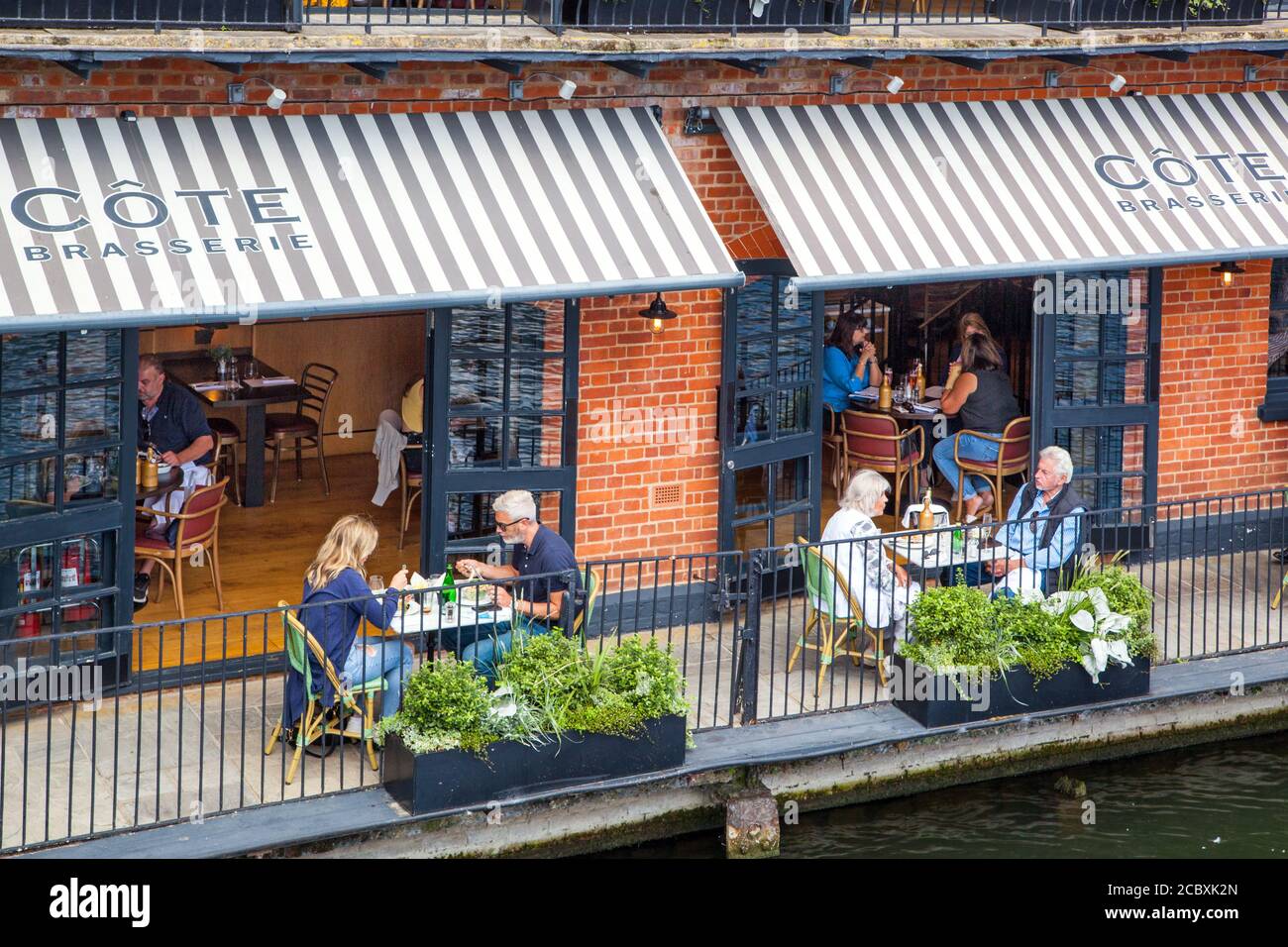 Dinners at the Cote brasserie riverside restaurant eating and drinking outside on the river Thames at Windsor and Eton England UK Stock Photo