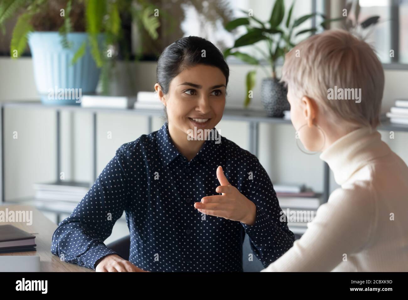 Two young multiracial employees discussing working issues. Stock Photo