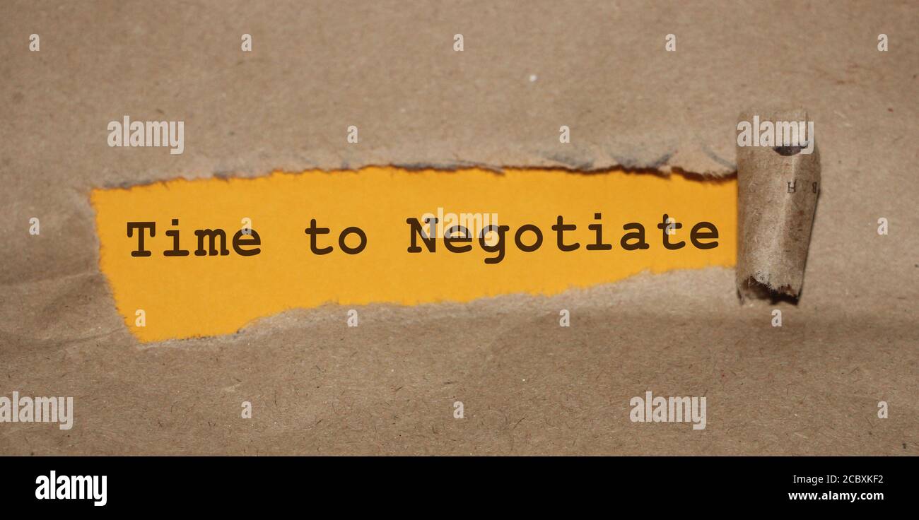 The text 'Time to negotiate' appearing behind torn paper. Business concept Stock Photo