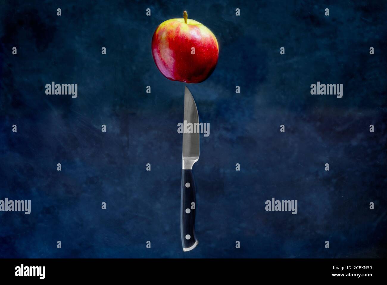 Red apple with fruit Knife on dark background. Food Levitation concept