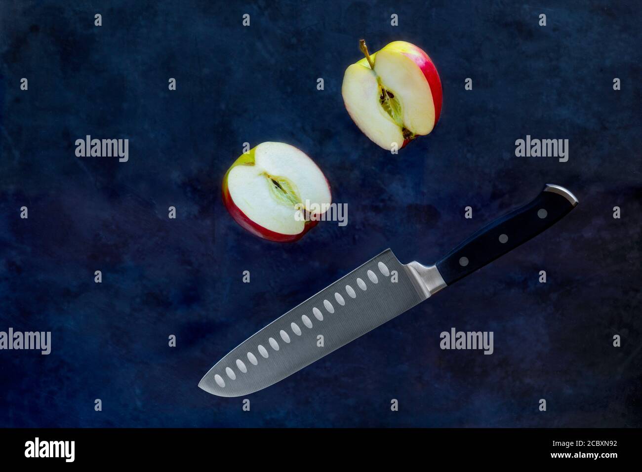 Red apple slices cut with fruit Knife on dark background. Food Levitation and copy space Stock