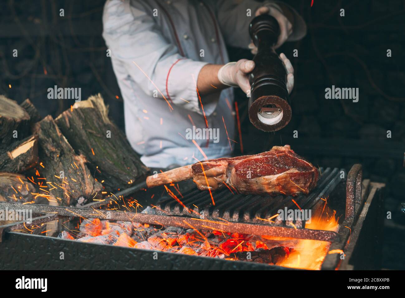 Chef Cooking steak. Cook turns the meat on the fire Stock Photo - Alamy